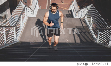 Urban fitness, man running on stairs and listening to music on headphones on outdoor exercise in Los Angeles. Health, motivation and a California city runner on steps for marathon training in morning Urban fitness, man running on stairs and listening to music on headphones on outdoor exercise in Los Angeles. Health, motivation and a California city runner on steps for marathon training in morning 127341251
