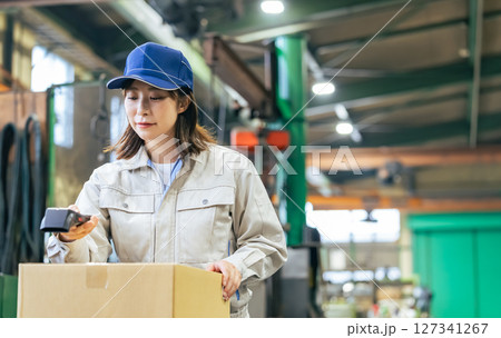 工場でハンディターミナルを使って商品を管理する女性作業員グループ 127341267