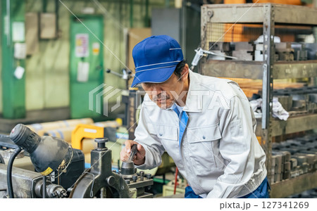 工場で機械を操作する男性作業員 工場で機械を操作する男性作業員 127341269