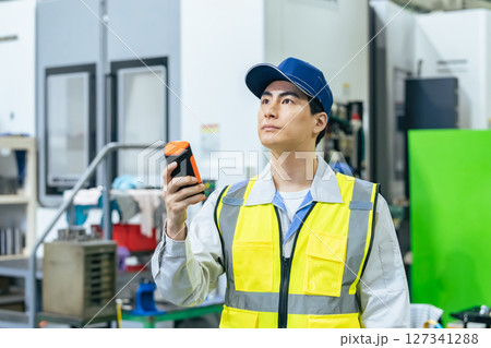工場でポータブル測定器を使う作業員 工場でポータブル測定器を使う作業員 127341288