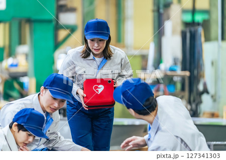 工場で倒れた作業員をAEDで救護するグループ 工場で倒れた作業員をAEDで救護するグループ 127341303