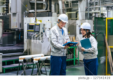 工場でタブレットを使って作業する作業員グループ 127341419