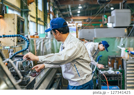 工場で機械を操作する男性作業員 工場で機械を操作する男性作業員 127341425