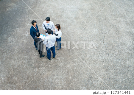 屋外に集まって話し合う会社従業員のグループ 127341441