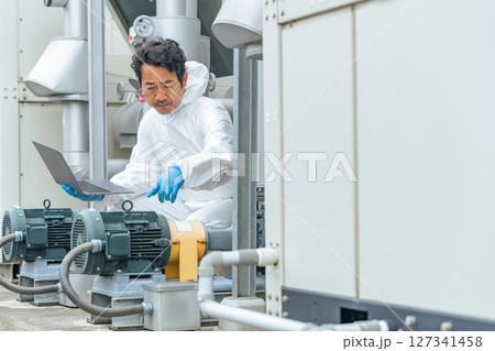 屋外機械を点検する男性作業員 屋外機械を点検する男性作業員 127341458