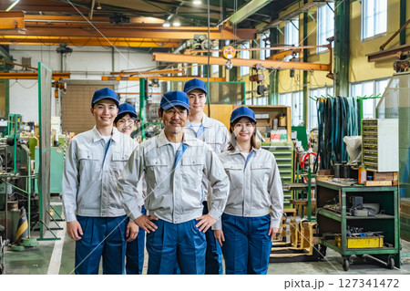 工場の中に立つ作業員グループの集合写真 127341472