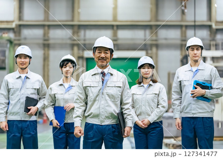工場の中で並んで立つ作業員のグループ 127341477