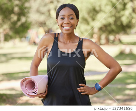 Portrait of black woman in park with yoga mat and smile in nature for health and fitness mindset and care. Exercise, zen and yoga, happy face on woman ready for pilates workout on grass in summer sun 127341656
