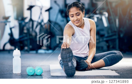 Stretching, fitness and water bottle with woman in gym for weightlifting, exercise and sports training. Challenge, wellness and workout with girl athlete and warm up for start, strong and cardio 127341893
