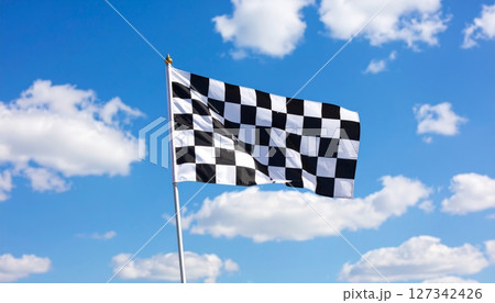 Race to success under a blue sky, the checkered flag signals the winning finish of a high-speed competition Race to success under a blue sky, the checkered flag signals the winning finish of a high-speed competition 127342426