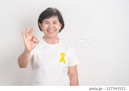 Elderly with Yellow Ribbon for concept of yellow September, Suicide prevention day, Childhood, July Sarcoma, bone cancer Awareness in children month, support survivor. Healthcare and World Cancer day Elderly with Yellow Ribbon for concept of yellow September, Suicide prevention day, Childhood, July Sarcoma, bone cancer Awareness in children month, support survivor. Healthcare and World Cancer day 127343521