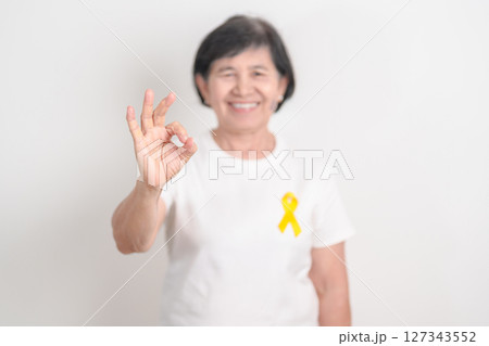 Elderly with Yellow Ribbon for concept of yellow September, Suicide prevention day, Childhood, July Sarcoma, bone cancer Awareness in children month, support survivor. Healthcare and World Cancer day 127343552