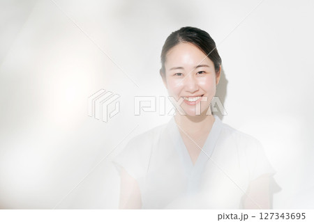 夏の日差しの中で微笑む20代の女性 127343695