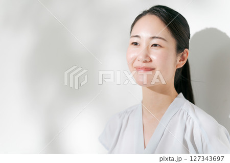 夏の日差しの中で微笑む20代の女性 夏の日差しの中で微笑む20代の女性 127343697