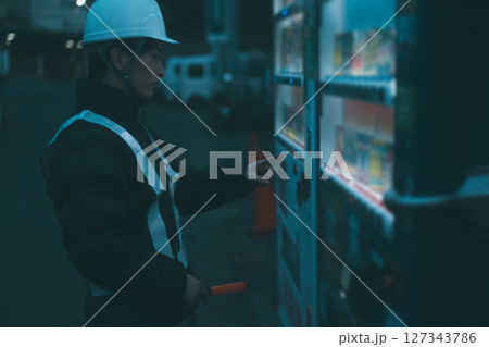 自販機で飲み物を買う休憩中の警備員 自販機で飲み物を買う休憩中の警備員 127343786