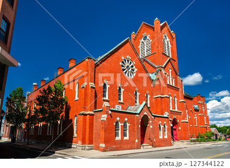 The red brick First United Methodist Church in Pittsfield, Massachusetts, United States, displays Gothic Revival arches, rose window and corner tower beneath a vivid summer sky. The red brick First United Methodist Church in Pittsfield, Massachusetts, United States, displays Gothic Revival arches, rose window and corner tower beneath a vivid summer sky. 127344122
