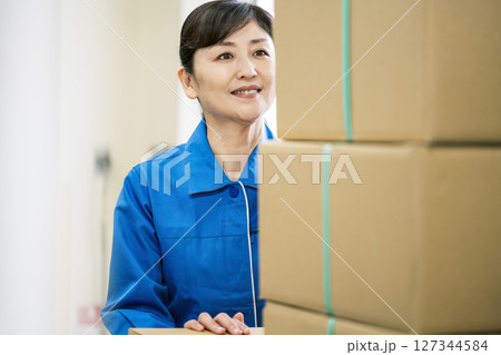 作業服を着て物流倉庫で働く50代の女性 作業服を着て物流倉庫で働く50代の女性 127344584