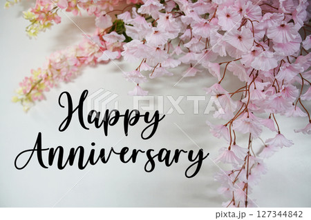 Happy Anniversary text with flowers decorations on wooden background 127344842
