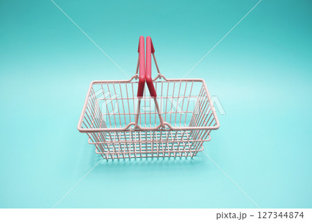 Pink empty shopping basket with space copy on blue background Pink empty shopping basket with space copy on blue background 127344874