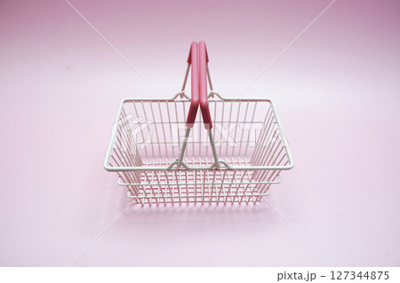Pink empty shopping basket with space copy on pink background 127344875