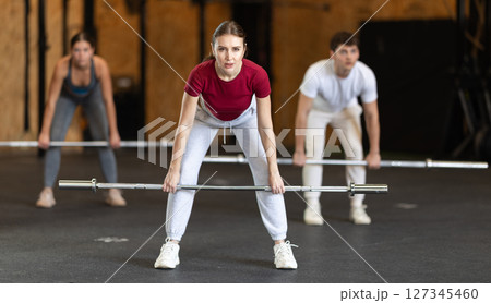 Woman lifting a barbell Woman lifting a barbell 127345460