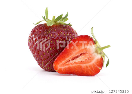 A close-up of a fresh, ripe strawberry, with a sliced section, on white. 127345830