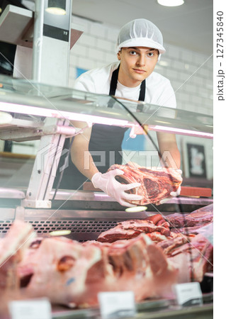 Guy seller works in specialized butcher shop 127345840