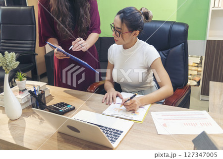 Diversity Two Businesswoman working together in office desk. Two cuacasian asian women look at financial report document as partner teamwork. Team leader coworker brainstorming executive entrepreneur 127347005