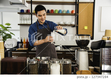 Coffee barista man make espresso shot from coffee maker hot cup. Cappuccino with milk in italian coffee shop cafe. Close up hands of barista use machine make brown latte art for customer cafeteria 127347284
