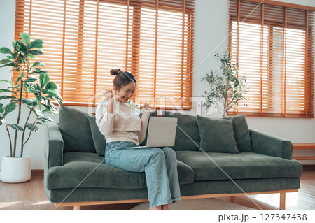 Funny euphoric young asian woman celebrating winning 127347438