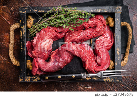 Beef cut Machete Skirt Steak, raw marble meat in wooden tray. black background. top view Beef cut Machete Skirt Steak, raw marble meat in wooden tray. black background. top view 127349579