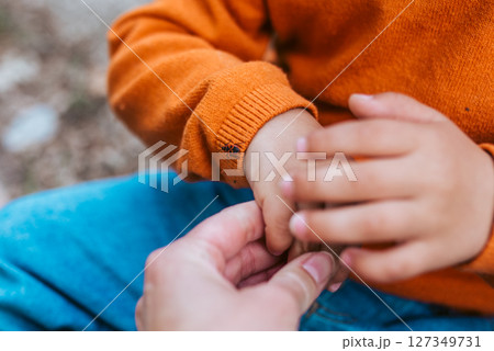 Close up of father and boy observing bug during nature walk Close up of father and boy observing bug during nature walk 127349731