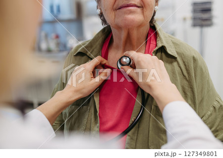 Geriatrician doctor examining elderly patient with stethoscope. Geriatrician doctor examining elderly patient with stethoscope. 127349801