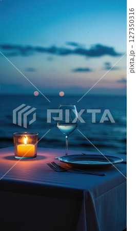 Candlelit Seaside Dinner Table for One at Twilight with Ocean Horizon 127350316