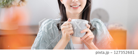 部屋で飲み物を飲んでリラックスするかわいい若い女性　のんびりティータイム 127352681