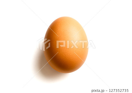 Closeup angled view of rustic brown chicken egg casting soft shadow on white surface isolated for culinary presentation and creative composition designs Closeup angled view of rustic brown chicken egg casting soft shadow on white surface isolated for culinary presentation and creative composition designs 127352735