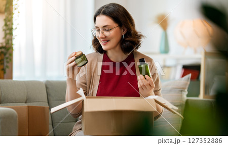 Woman is unpacking cardboard Woman is unpacking cardboard 127352886