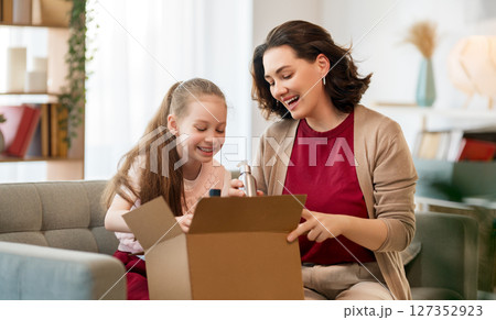 Mother and daughter are unpacking cardboard 127352923