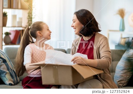 Mother and daughter are unpacking cardboard 127352924