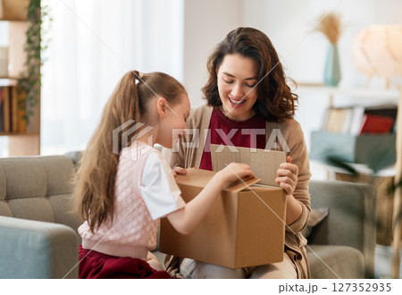 Mother and daughter are unpacking cardboard 127352935
