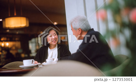 カフェで会話を楽しむ中年夫婦の幸せなひととき 127353001
