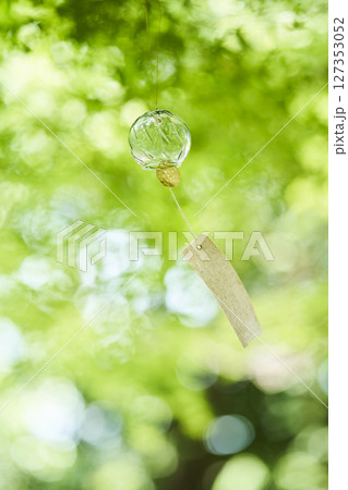 夏の木漏れ日の下で風に揺れる風鈴 夏の木漏れ日の下で風に揺れる風鈴 127353052