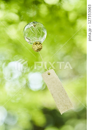 夏の木漏れ日の下で風に揺れる風鈴 127353063