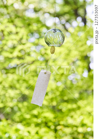 夏の木漏れ日の下で風に揺れる風鈴 夏の木漏れ日の下で風に揺れる風鈴 127353097