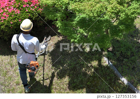 植木職人　エンジン式草刈り機で草地の刈込作業風景 127353156