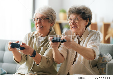 Two senior women playing console game Two senior women playing console game 127353544