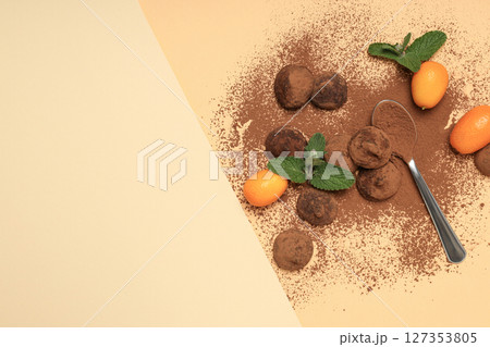 Chocolate truffles with kumquat and mint on a light background Chocolate truffles with kumquat and mint on a light background 127353805