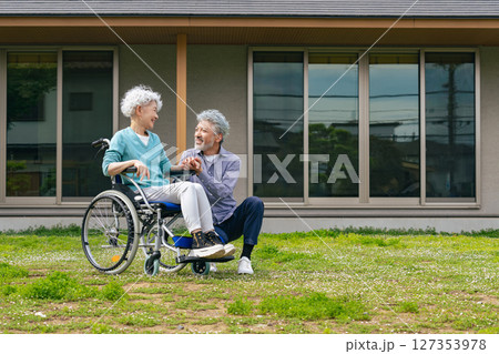 住宅の前で話す車椅子に乗ったシニア夫婦 住宅の前で話す車椅子に乗ったシニア夫婦 127353978