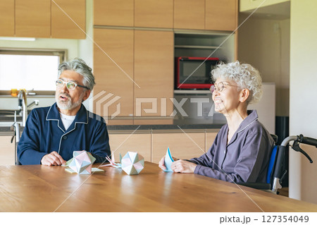 折り紙をする車椅子に乗ったシニアカップル 折り紙をする車椅子に乗ったシニアカップル 127354049
