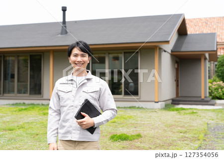 住宅の前に立つ男性作業員 住宅の前に立つ男性作業員 127354056